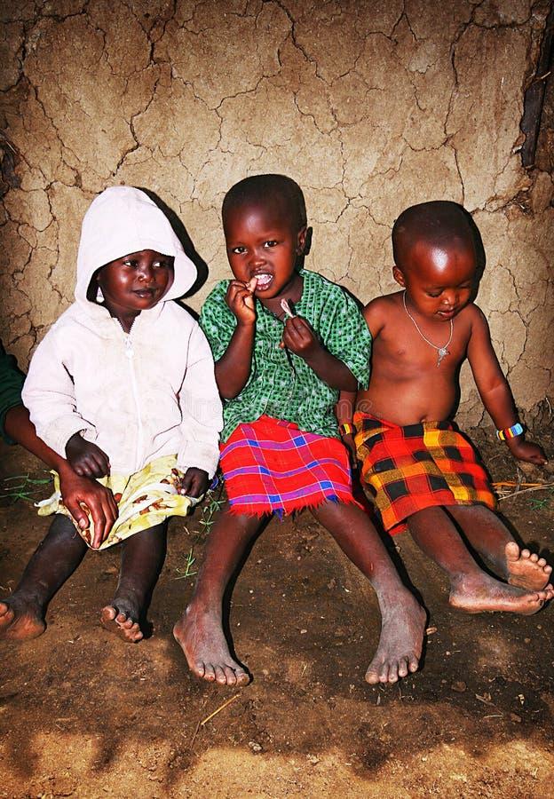 Three young Maasai children sitting together